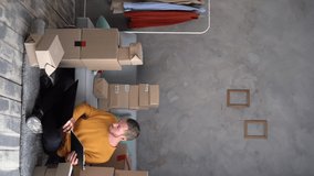 Small business owner man prepare parcel box and check online orders of product for deliver to customer on laptop computer. SME e-commerce telemarketing