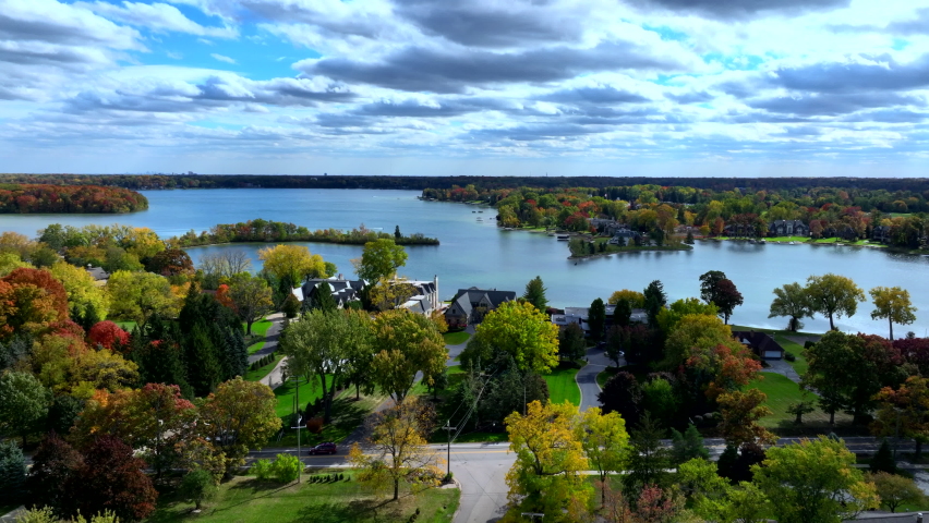 Aerial drone footage of Cass Lake and Orchard Lake in West Bloomfield Michigan during Fall. Beautiful autumn day with colorful leaves all around