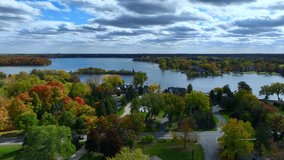 Aerial drone footage of Cass Lake and Orchard Lake in West Bloomfield Michigan during Fall. Beautiful autumn day with colorful leaves all around