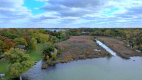 Aerial drone footage of Cass Lake and Orchard Lake in West Bloomfield Michigan during Fall. Beautiful autumn day with colorful leaves all around