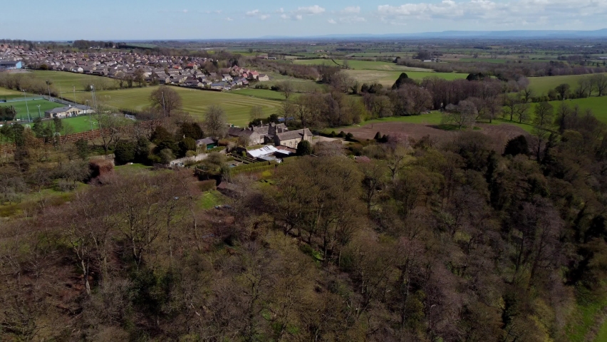 Aerial drone pan across Richmond School and Richmond town centre with The River Swale in the foreground