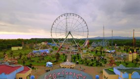 Top view of amusement park with Ferris wheel and roller coaster at sunset in Georgia at Tsitsinatela Park. Ferris wheel with air illumination. Recreation area of Georgian park on Black Sea coast. - Powered by Shutterstock - Get 15% off with code: PIKWIZARD15