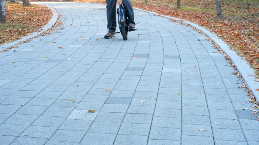 A man rides electric unicycle in city park.