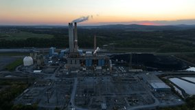 Coal burning power plant generates electricity. Fossil fuel carbon footprint, dirty smoke exhaust theme. Aerial view. Power lines at sunset. - Powered by Shutterstock - Get 15% off with code: PIKWIZARD15