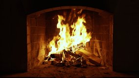Warm Cozy Fireplace with Real Wood Burning in it. Cozy Winter Concept. Slow Motion. A Looping Clip of a Fireplace with Medium Size Flames. UHD TV screen saver. Video for meditation