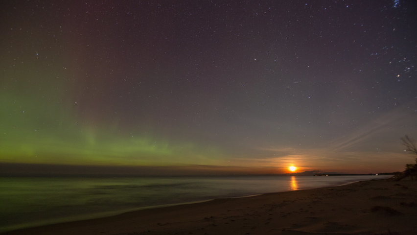Panning time-lapse of the Northern Lights (aurora borealis) in the sky above the shoreline of Lake Superior. Shot near Marquette, Michigan in 4K