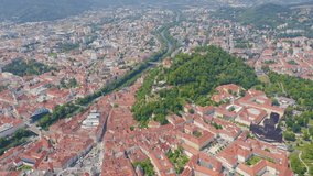 Inscription on video. Graz, Austria. The historic city center aerial view. Mount Schlossberg (Castle Hill). Name is burning, Aerial View, Departure of the camera