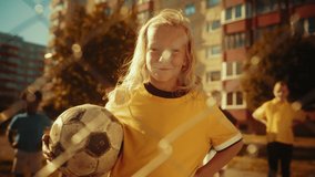 Portrait of a Cute Girl in Yellow T-Shirt Holding a Soccer Ball on a Field in the Neighborhood. Young Female Football Player Looking at Camera, Smiling. Concept of Sports, Childhood, Friendship. - Powered by Shutterstock - Get 15% off with code: PIKWIZARD15