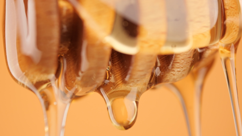 A Honey Dipper Drizzling honey, macro shot. Honey dripping, pouring from wooden dipper close up. Healthy organic honey Royalty-Free Stock Footage #1096108449