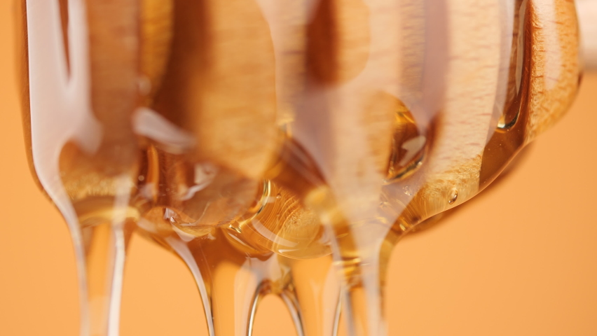 A Honey Dipper Drizzling honey, macro shot. Honey dripping, pouring from wooden dipper close up. Healthy organic honey | Shutterstock HD Video #1096108449