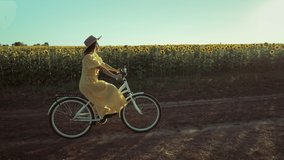 Rural woman in timeless dress riding retro styled white bicycle on country road alone near sunflowers field. Vintage fashion, amazing adventure, countryside activity, healthy lifestyle. - Powered by Shutterstock - Get 15% off with code: PIKWIZARD15