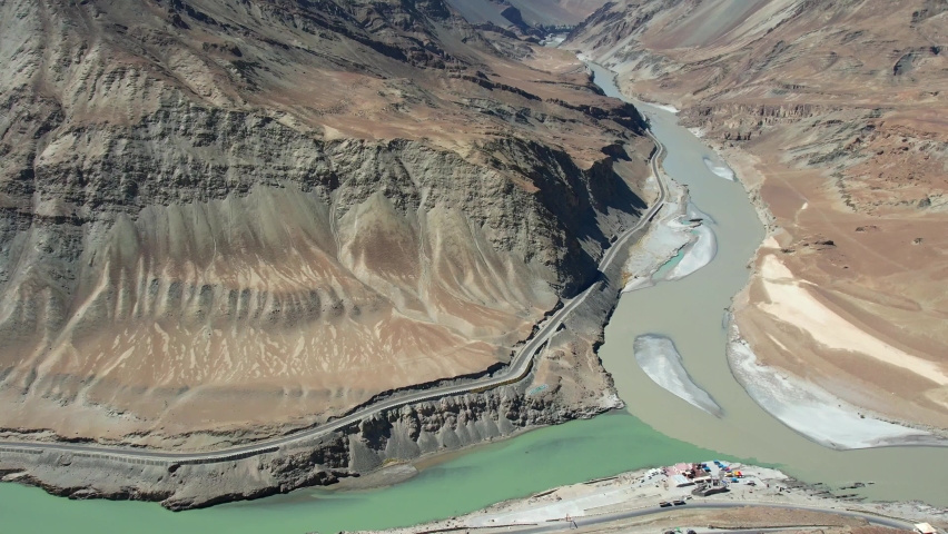Aerial view of Sangam – the confluence of the Indus river (green colour) and the Zanskar river (blue or brown colour depending on the season) in Ladakh, India. 