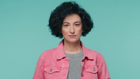 Headshot of sad serious mature beautiful woman with stylish curly hairstyle in bright pink denim jacket, looking straight at camera, isolated on green background with copy space for advertising copy - Powered by Shutterstock - Get 15% off with code: PIKWIZARD15