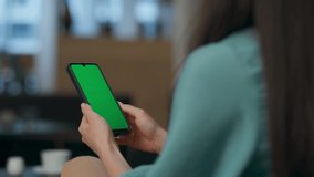 Unknown woman resting watching mockup smartphone video at office. Closeup manager hands typing green screen cellphone touchpad indoors. Anonymous ceo arms enjoying horizontal chroma key mobile