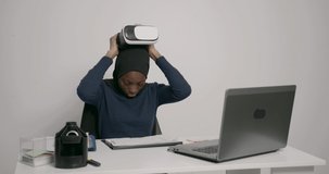 Black muslim woman testing vr headset at office
