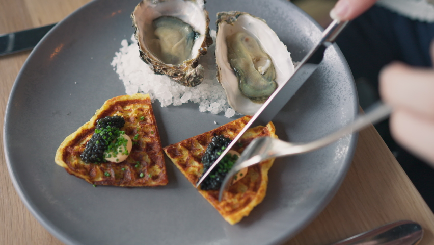 woman eating tasty gourmet seafood dinner at luxury restaurant, close-up