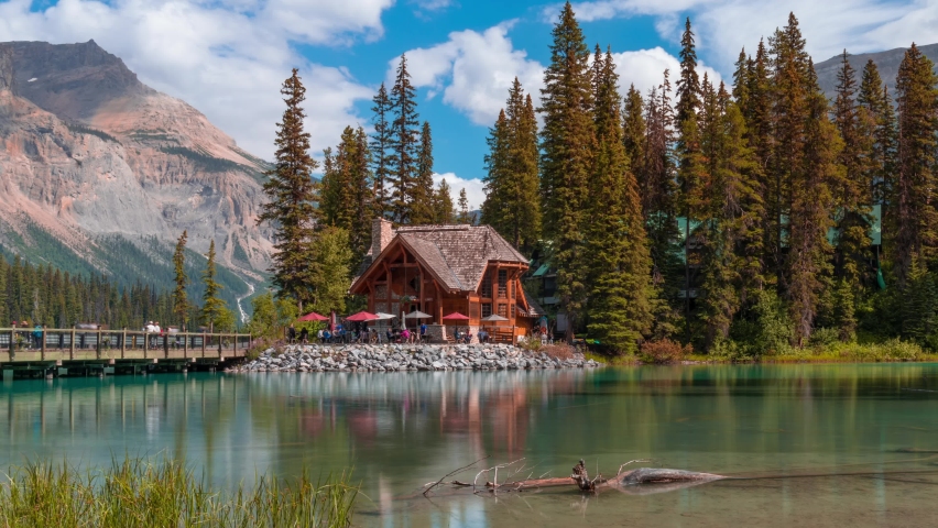 4K time-lapse UHD video of scenery of wooden house with rocky mountains and cloudy blowing reflection on Emerald Lake,a Glacial Lake at Yoho national park in the mountain parks of the Canadian Rocky