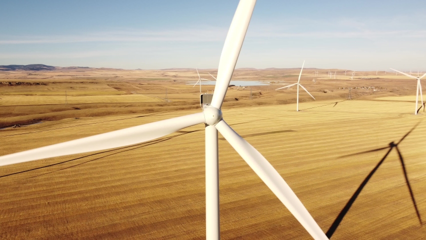 Aerial Wind turbine spinning cinematic flight overlooking Canadian prairies near Pincher Creek Alberta Canada. Royalty-Free Stock Footage #1096152753