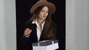 A cute girl in a hat receives a gift and is very happy about it