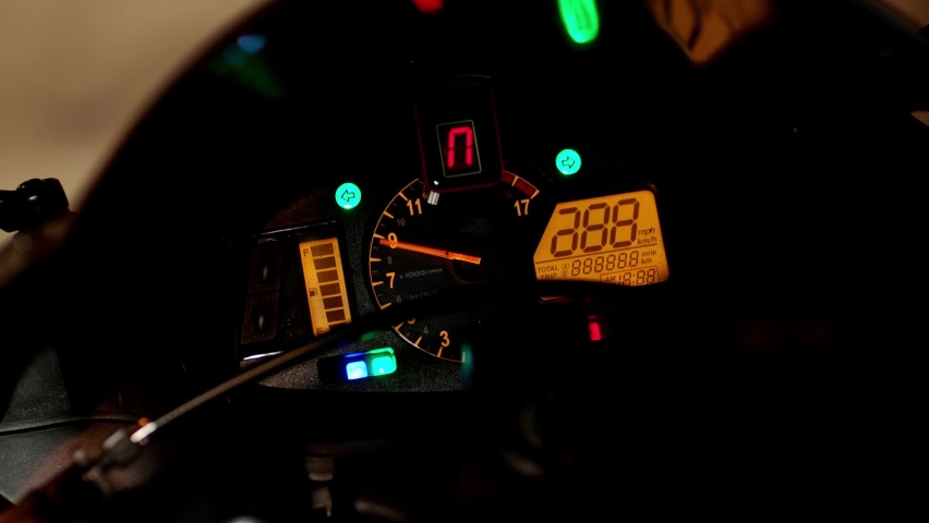 Motorcyclist turns the ignition key of the motorcycle and the speedometer needle sways smoothly. Motorcycle dashboard with speedometer close up, ignition on. Close-up arrow speedometer of sports bike