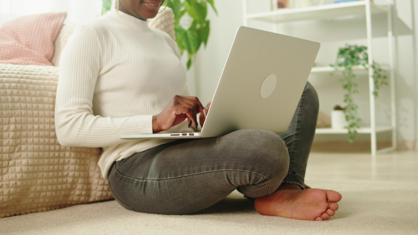 Native African American woman using laptop close-up. Young female student working remotely at computer in living room, freelancer. Remote work. Communicating with friends via internet. | Shutterstock HD Video #1096179577