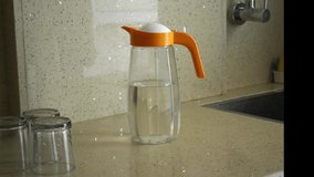 A Closeup video of a person filling a glass tumbler with drinking water in Kitchen area.