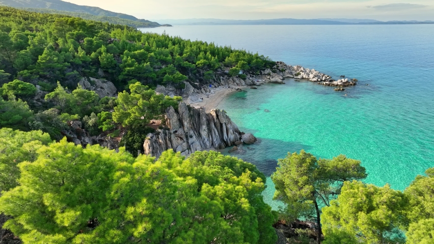 Aerial shot of lagoon with turquoise water, sandy beach and pine trees. Beautiful orange beach Kavourotripes , Sitonia, Halkidiki, Greece Royalty-Free Stock Footage #1096183881