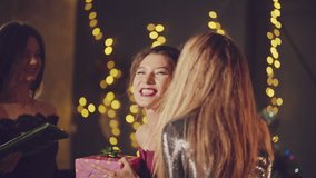 Joyful woman greeting friends with hugs receiving gifts for birthday or christmas and thanking them at home before dinner. Party or birthday celebration of New year and merry Christmas  - Powered by Shutterstock - Get 15% off with code: PIKWIZARD15