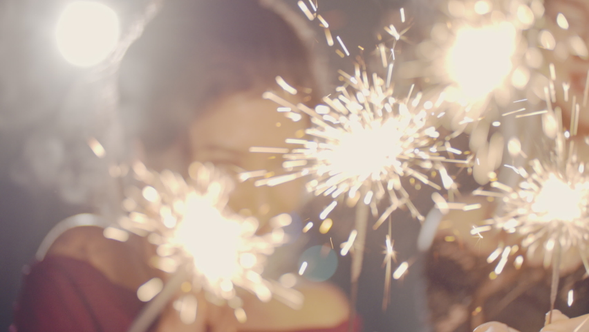 Closeup of hands lighting sparklers. Multiracial young people celebrate New YEAR Christmas Day, smile and laugh. Merry Christmas winter holiday concept. Friends spend time together. Festive emotional Royalty-Free Stock Footage #1096187125