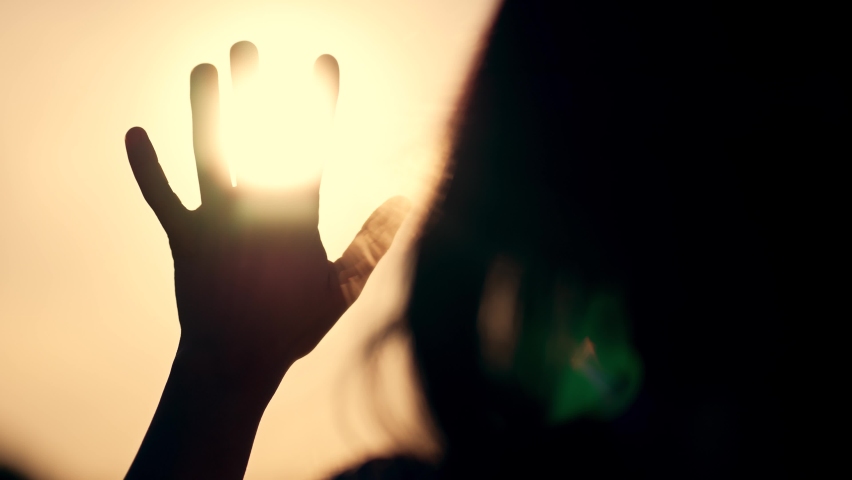 Hand of happy girl at sunset. Sunset between hands of girl. Happy girl with long hair dreamily stretches out her hand to sun. Child's dream hand to sun. happy family concept.Religion and faith concept Royalty-Free Stock Footage #1096198219