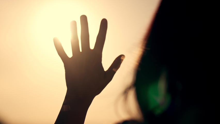 Hand of happy girl at sunset. Sunset between hands of girl. Happy girl with long hair dreamily stretches out her hand to sun. Child's dream hand to sun. happy family concept.Religion and faith concept Royalty-Free Stock Footage #1096198219