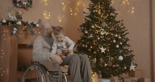 Senior man in wheelchair with baby grandson