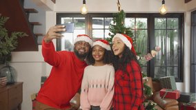 An African American black family, woman, father, mother and kid girl taking a selfie by phone in party on Merry Christmas Eve Xmas on holiday. Celebration at home. People lifestyle. - Powered by Shutterstock - Get 15% off with code: PIKWIZARD15