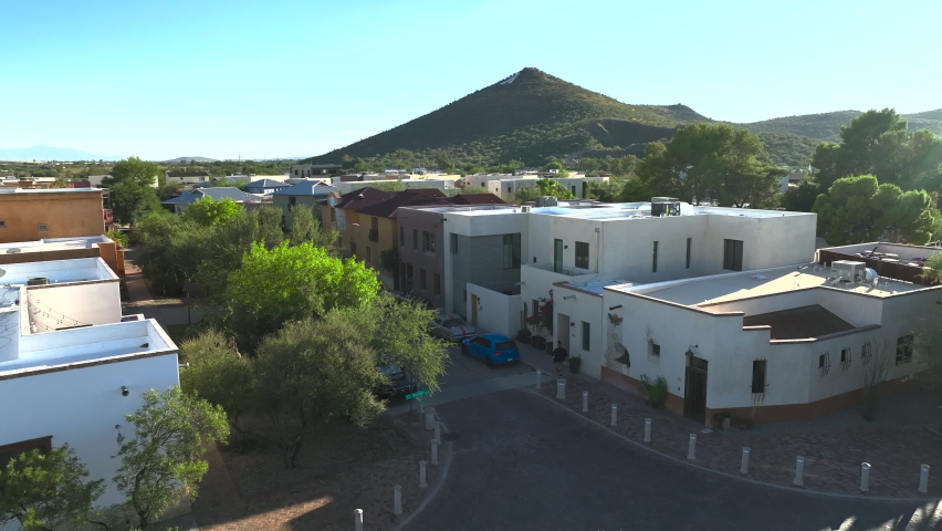 Aerial shot of homes, townhomes, apartments in Tuscon Arizona into the sun, slowly rotating drone shot.