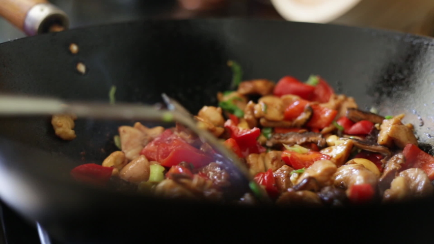 Stir-frying chicken and vegetables in a seasoned wok Royalty-Free Stock Footage #1096220867