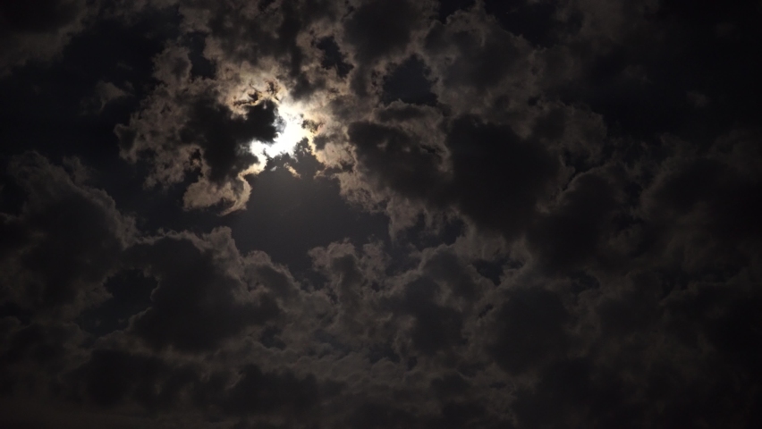 Full moon in the clouds at night.
