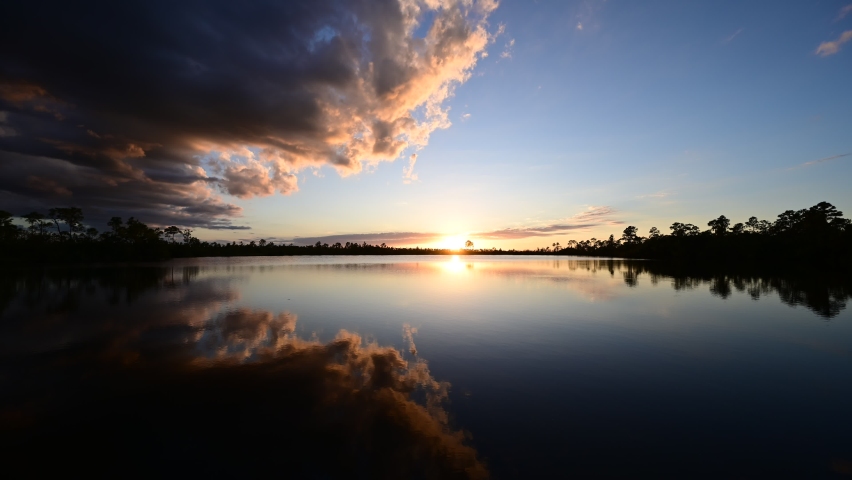 Timelapse of sunset cloudscape and twilight over Pine Glades Lake in Everglades National Park, Florida 4K.