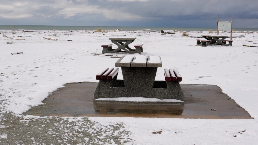 Snow-covered picnic table in a park.