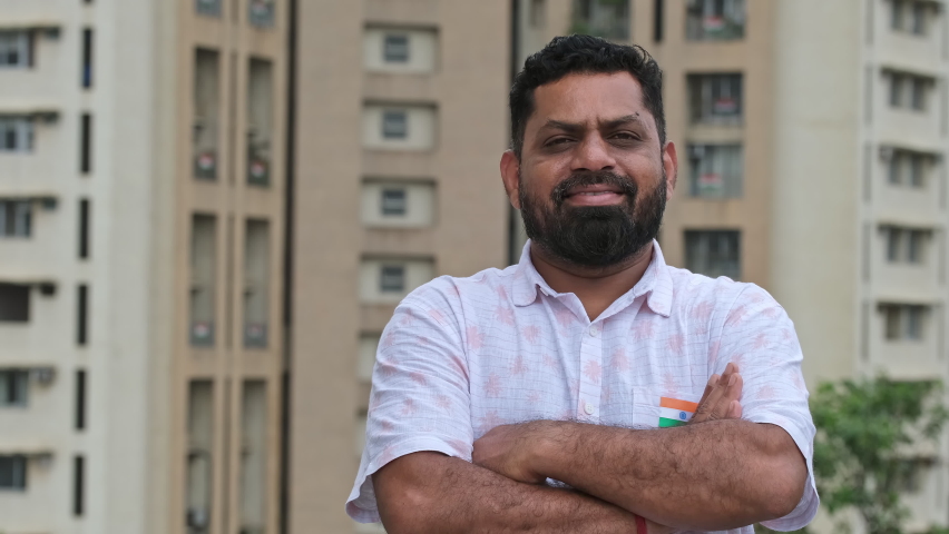 Handsome middle age Indian bearded man smiling and looking into the camera confidentially during Independence day at the office. Sales manager, professional leader, company employee, close-up portrait