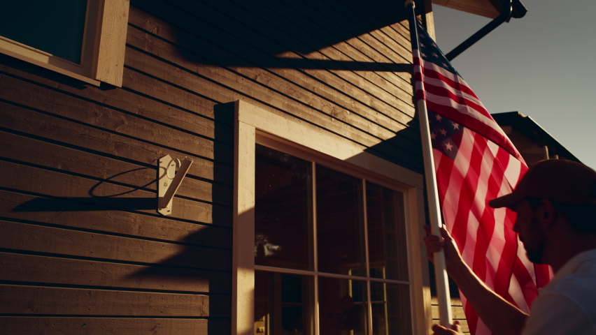 Close Up of a Honorable American Patriot Putting an American Stars and Stripes National Flag on a Wall of His Private Residential Area Home. Homeowner Raising a US Flag for Fourth of July Celebration. Royalty-Free Stock Footage #1096242487