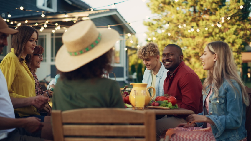 Family and Multiethnic Diverse Friends Gathering Together at a Garden Table. People Eating Grilled and Fresh Vegetables, Sharing Tasty Salads for a Big Family Celebration with Relatives. Royalty-Free Stock Footage #1096242607