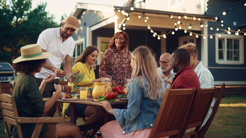 Big Family Vegetarian Party Gathered Together at a Table with Relatives and Friends. Young and Senior People are Eating Vegan Food, Drinking, Passing Dishes, Joking and Having Fun. Royalty-Free Stock Footage #1096242639