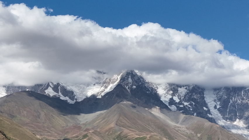 Flight over the mountains with bachground of Mount Shkhara in the region of Svaneti, Georgia