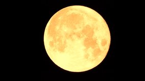 A glowing golden huge full moon seen from earth through the atmosphere against a starry night sky. A large full moon moves across the sky, the moon moving from the left frame to the right. - Powered by Shutterstock - Get 15% off with code: PIKWIZARD15