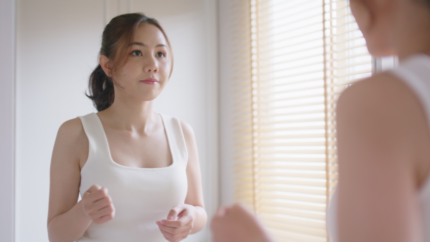 Young adult asia people woman hug love arm around believe trust smile look at mirror in body skin care. Single asian lady girl self esteem talk pride proud of myself life in morning fresh at cozy home Royalty-Free Stock Footage #1096251473