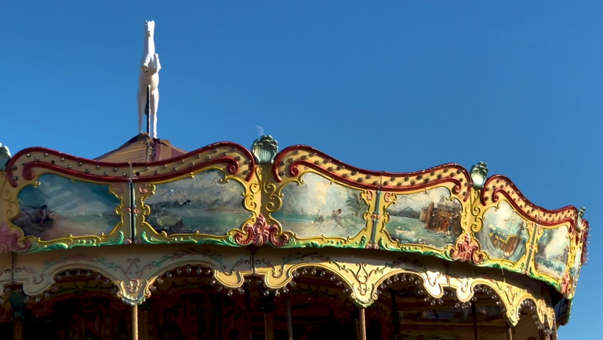 An antique carousel spinning in front of the moon.