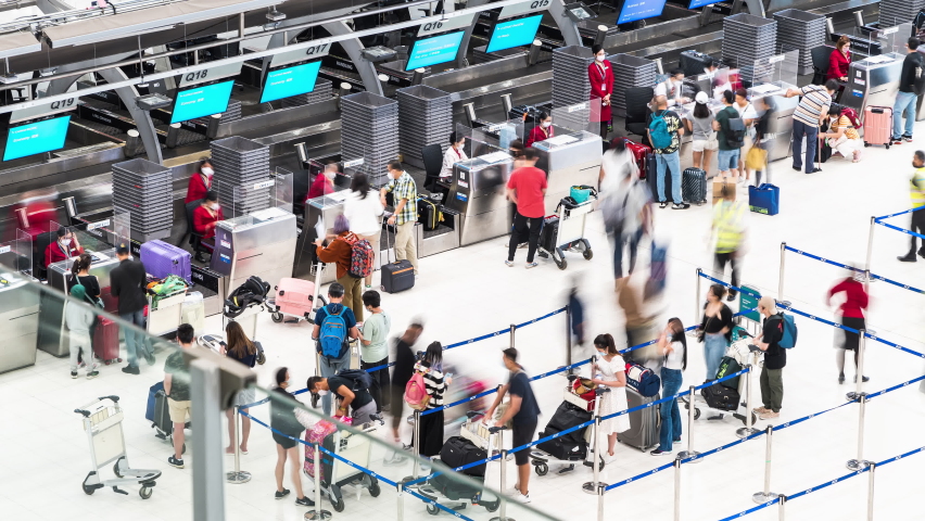 Bangkok, Thailand - 27 Oct, 2022: Time-lapse of crowded traveler people at international airport check in counter. Air transportation, travel abroad holiday vacation, oversea tourism business concept