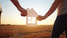 paper house happy family. friendly family hands holding paper house the glare of the sun shine through the window a beautiful sunset. mortgage business construction lifestyle concept. house dreams - Powered by Shutterstock - Get 15% off with code: PIKWIZARD15