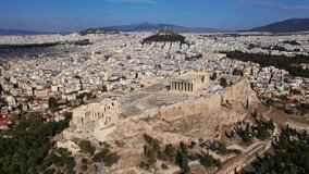 Aerial drone cinematic video of iconic Acropolis hill and the Parthenon a Unesco World Heritage Masterpiece of ancient times, Athens historic centre, Attica, Greece