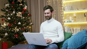 Happy handsome male employee freelancer business man working at home online remotely using laptop sitting at home during winter New Year Christmas holidays Typing browsing, chatting computer indoor - Powered by Shutterstock - Get 15% off with code: PIKWIZARD15